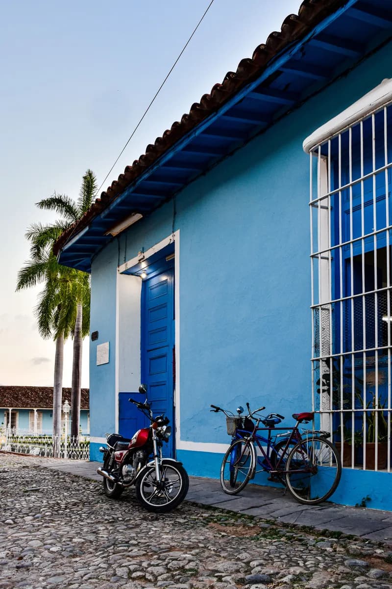 Imagen de ejemplo de BookNoFees: Fachada azul de una casa con bicicletas en Trinidad, Cuba