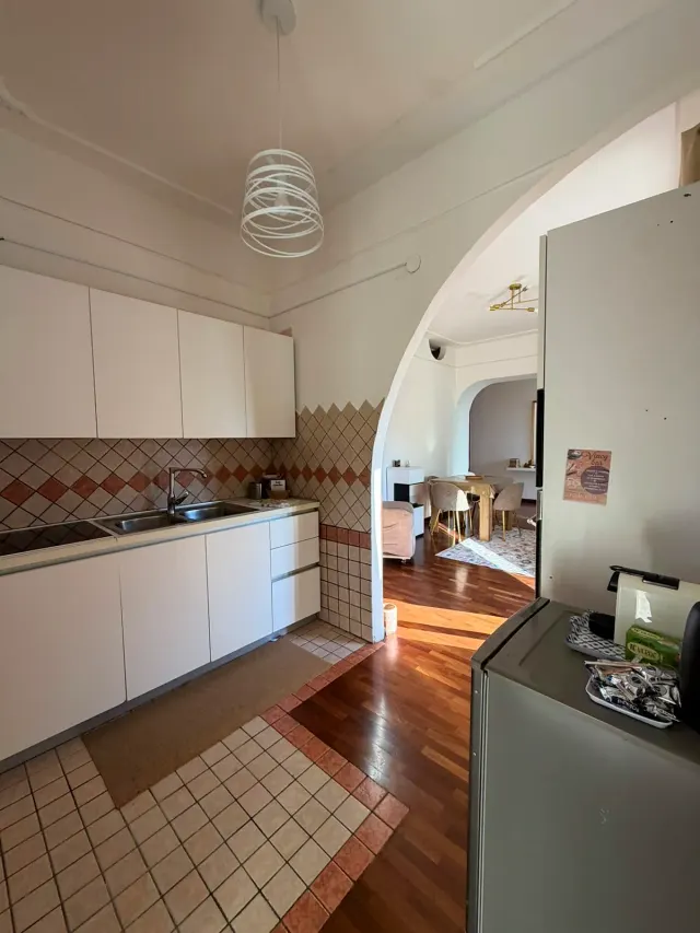 BookNoFees: alojamiento de vacaciones en Castellammare Di Stabia, La campaña, Italia – Cocina con gabinetes blancos, salpicadero de azulejos y puerta con arco que da al comedor