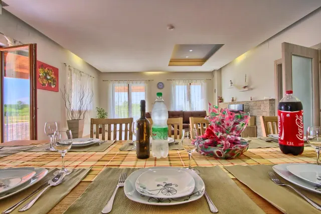 BookNoFees: alojamiento de vacaciones en Štokovci, Croacia – una mesa de comedor con platos y botellas de vino sobre ella en Villa Stokovci, en Štokovci