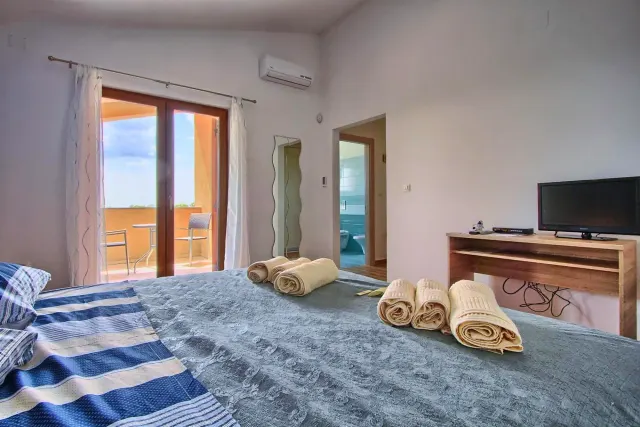 BookNoFees: alojamiento de vacaciones en Štokovci, Croacia – una habitación con una cama, toallas y un piano en Villa Stokovci, en Štokovci