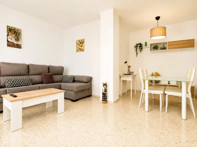 BookNoFees: alojamiento de vacaciones en Jerez De La Frontera – Sala con sofá gris y área de comedor con mesa de vidrio