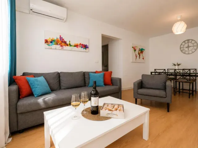 BookNoFees: alojamiento de vacaciones en Jerez De La Frontera – una sala de estar con un sofá y una mesa con copas de vino en Buleria, en Jerez de la Frontera