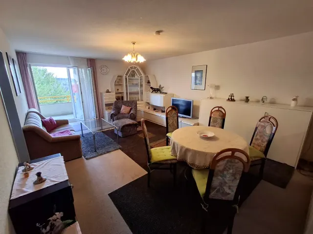 BookNoFees: alojamiento de vacaciones en Gailingen – Sala y comedor con sofá, mesa de comedor y acceso al balcón