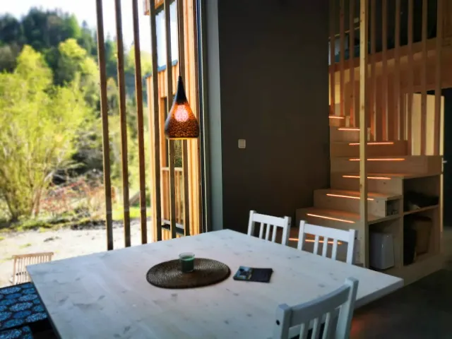BookNoFees: alojamiento de vacaciones en Hieflau, Estiria, Austria – Comedor con mesa blanca, lámpara colgante y escalera de madera con iluminación