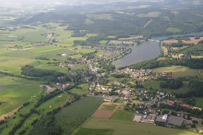 El lago Sorpesee visto desde el aire, con el pueblo de Amecke en su orilla oriental y las colinas boscosas del Sauerland a su alrededor