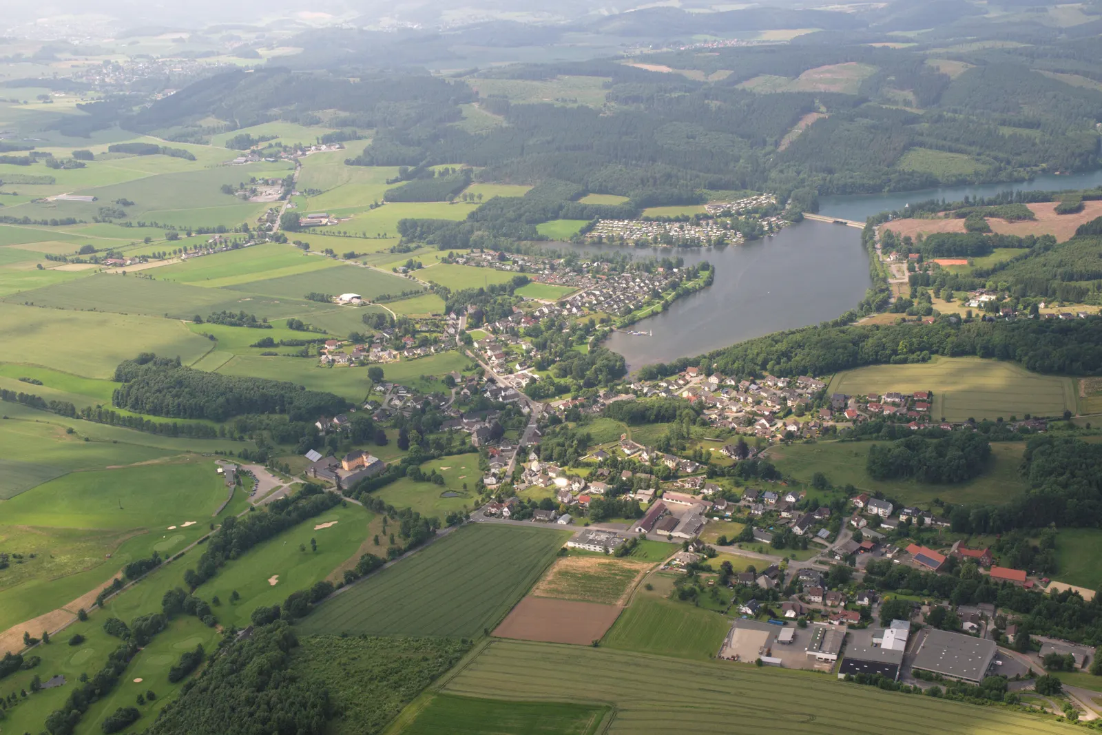 El lago Sorpesee visto desde el aire, con el pueblo de Amecke en su orilla oriental y las colinas boscosas del Sauerland a su alrededor