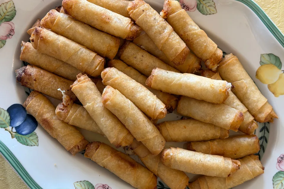 BookNoFees: Foto de ejemplo: Rollitos de primavera fritos y dorados en un plato estampado