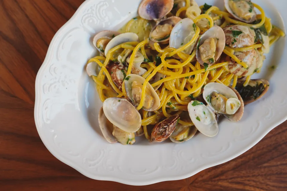 BookNoFees: Foto de ejemplo: Espaguetis con almejas en un plato blanco